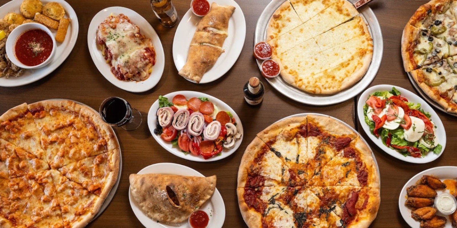 A table filled with pizzas and Italian dishes at Anna’s Pizzeria