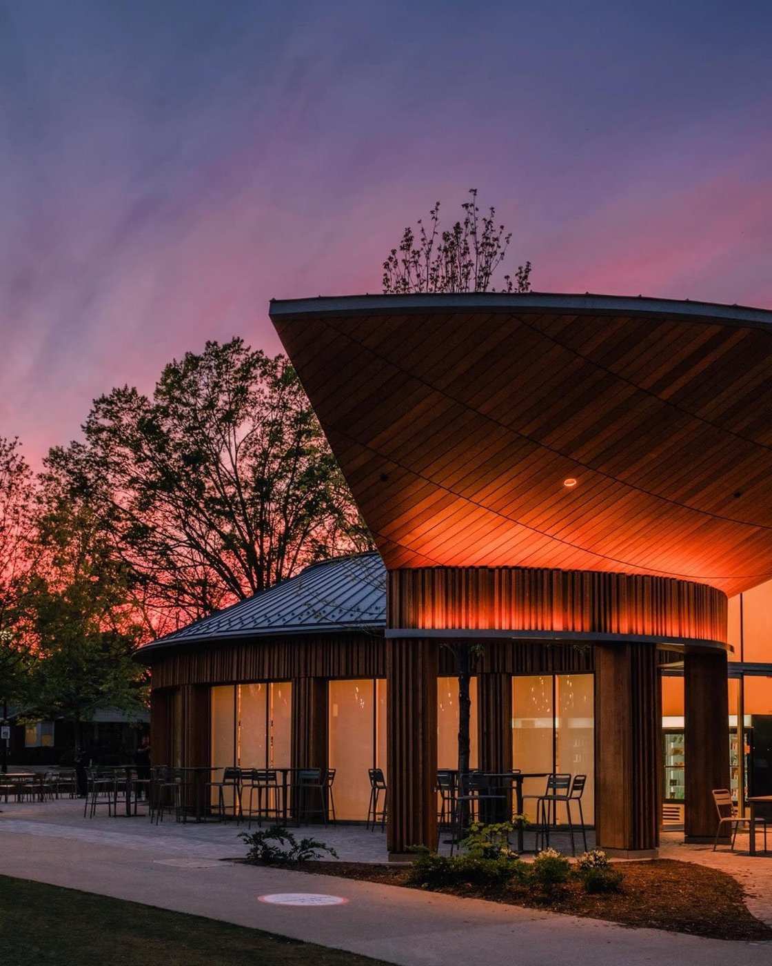 Illuminated wooden pavilion and outdoor seating at Downtown Cary Park