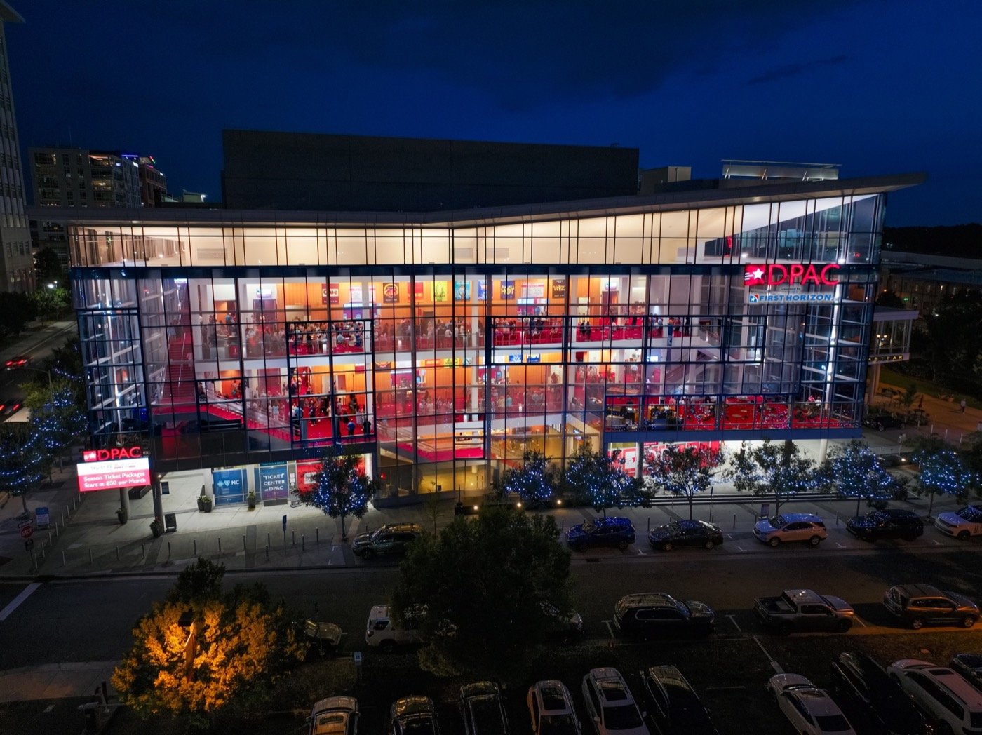 Illuminated glass facade of the Durham Performing Arts Center at night