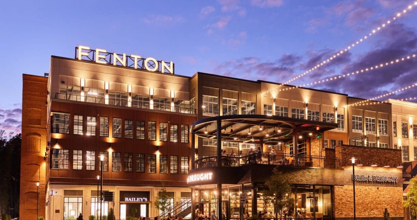 Illuminated restaurants and modern brick buildings at Fenton in Cary