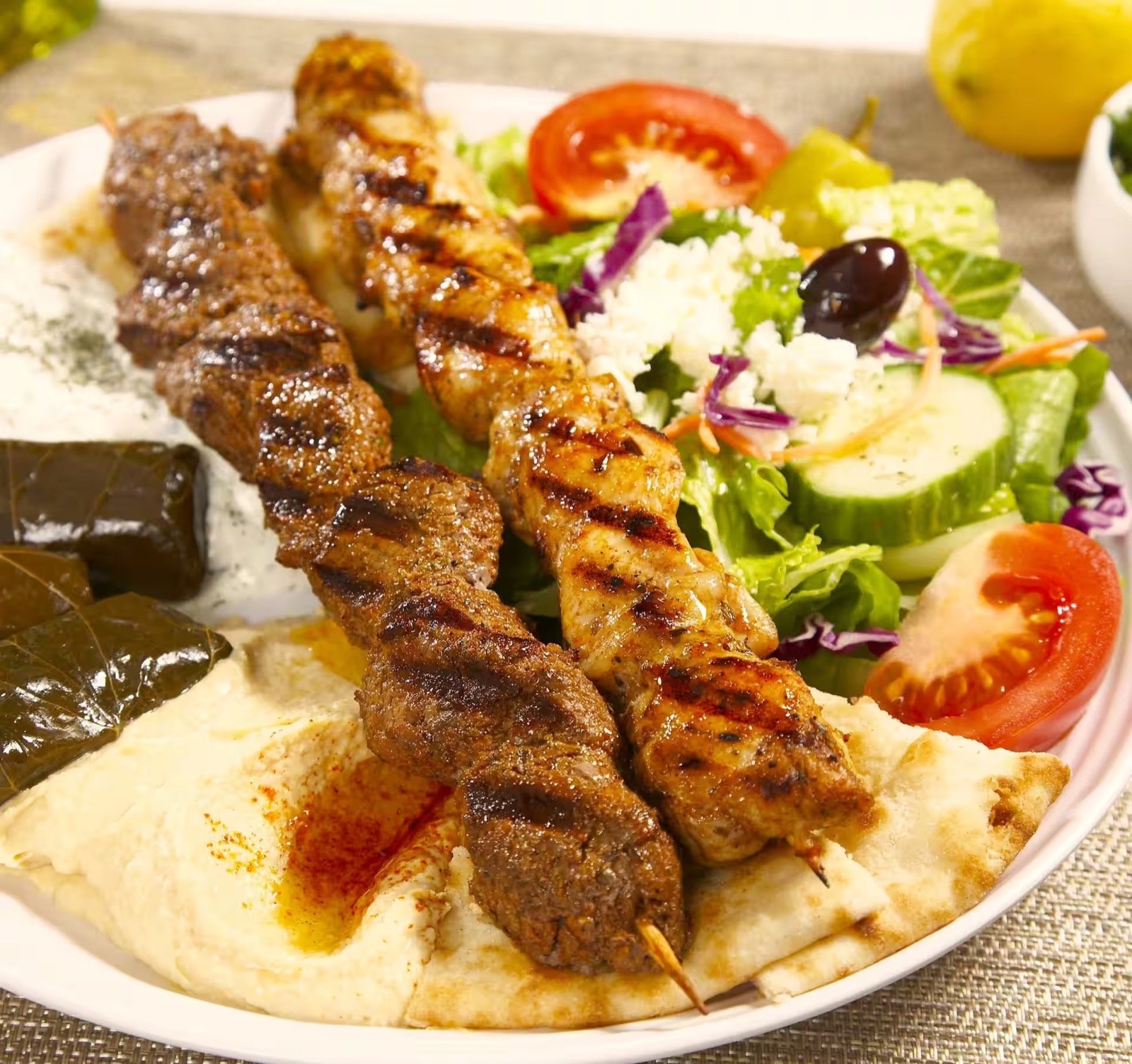 Chicken and beef kabobs with salad and Mediterranean sides at Greek Fiesta