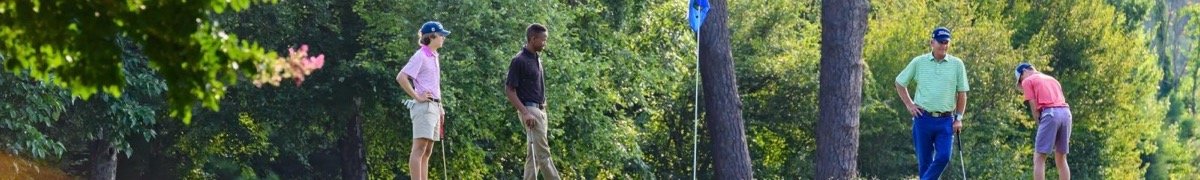Golfers putting on a tree-lined green at Hillandale Golf Course