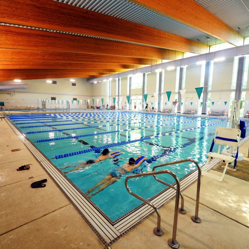 Swimmers using the bright indoor lap pool at Homestead Aquatic Center