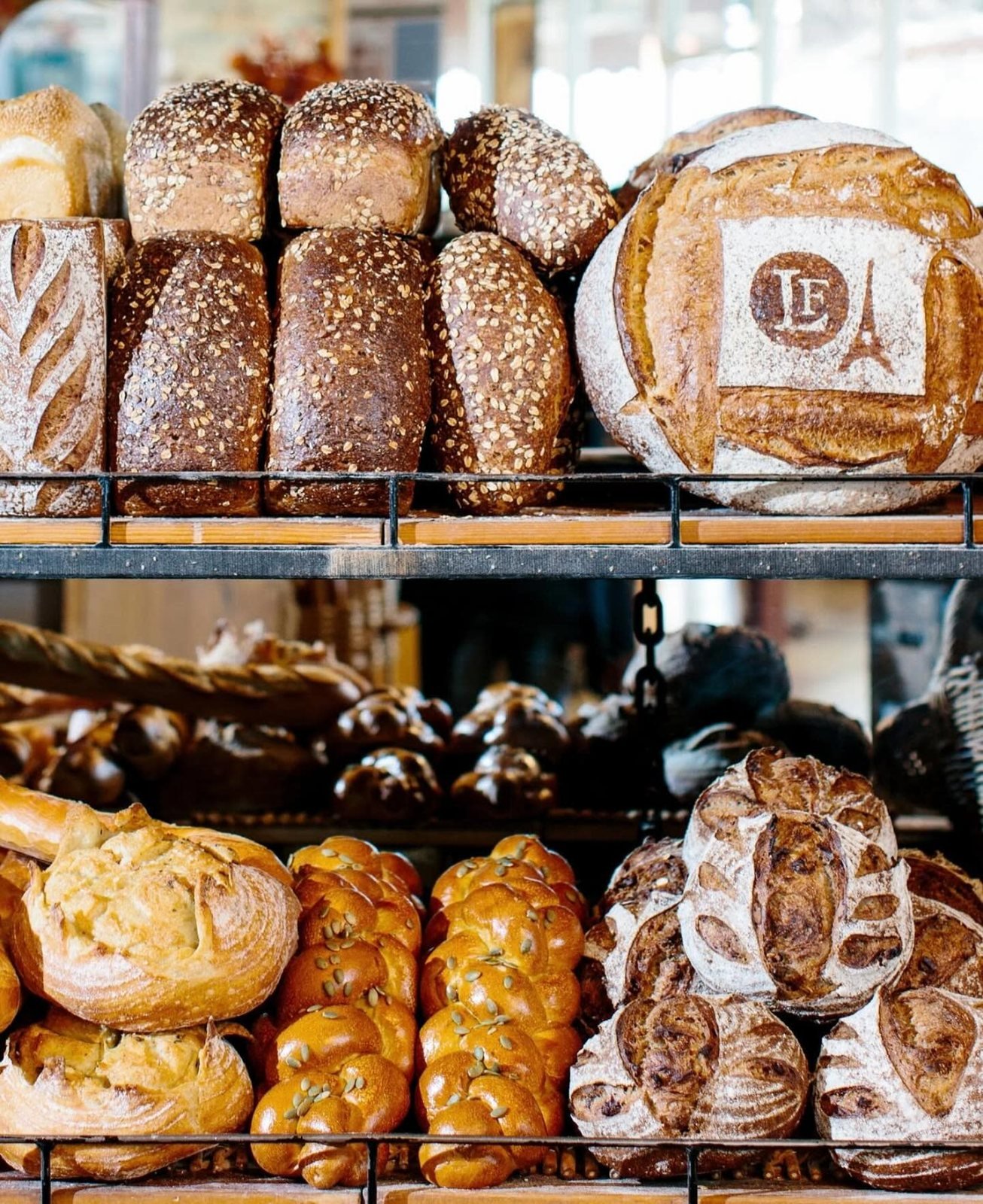 Fresh artisan loaves on bakery racks at La Farm Bakery