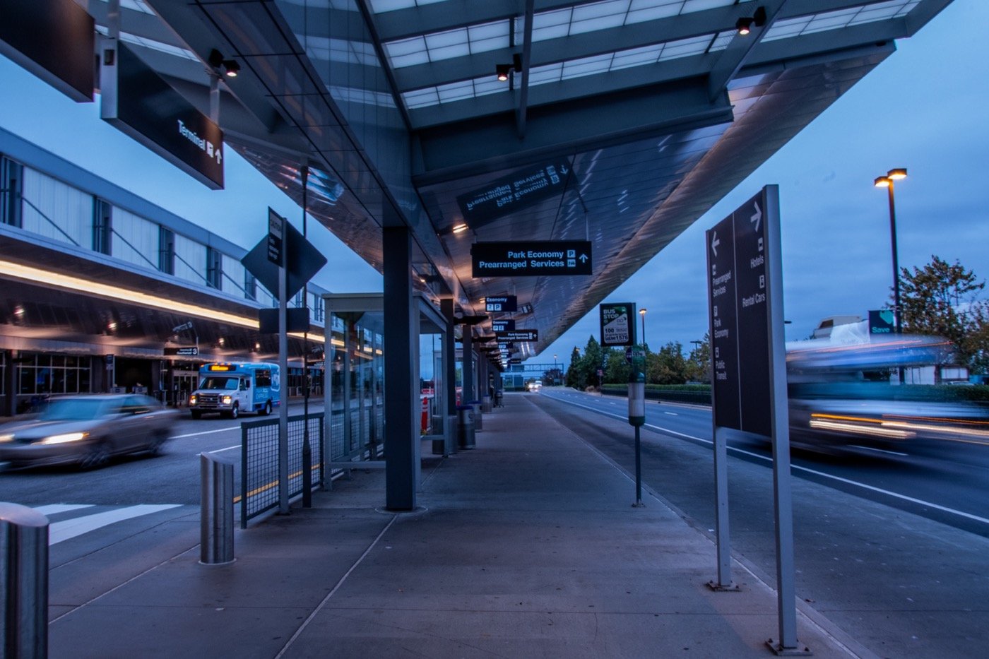 Passenger pickup area and ground transportation signs outside an RDU terminal