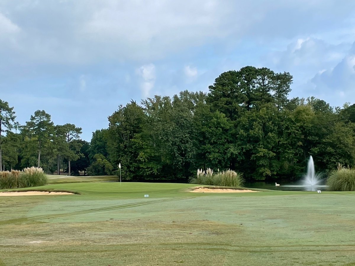 A green, bunkers, and a pond fountain at Wendell Country Club