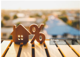 Wooden house and percent symbols representing mortgage rates