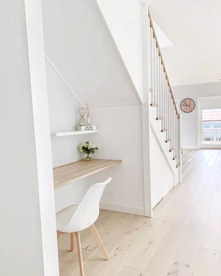 Compact desk and shelving beneath a staircase